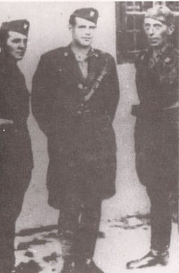 Three men in military uniforms stand together in a vintage, black-and-white photo.